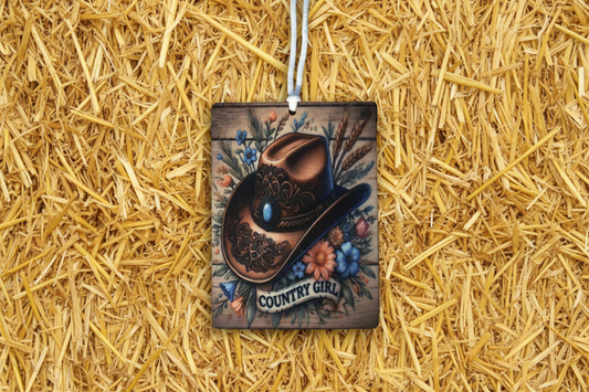 Decorative keychain with cowboy hat design on a straw background
