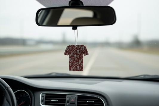 Floral-patterned shirt-shaped pendant on a chain against a wooden background